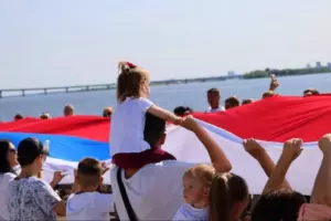 Многодетные семьи растянули 140-метровый флаг России на набережной Саратова